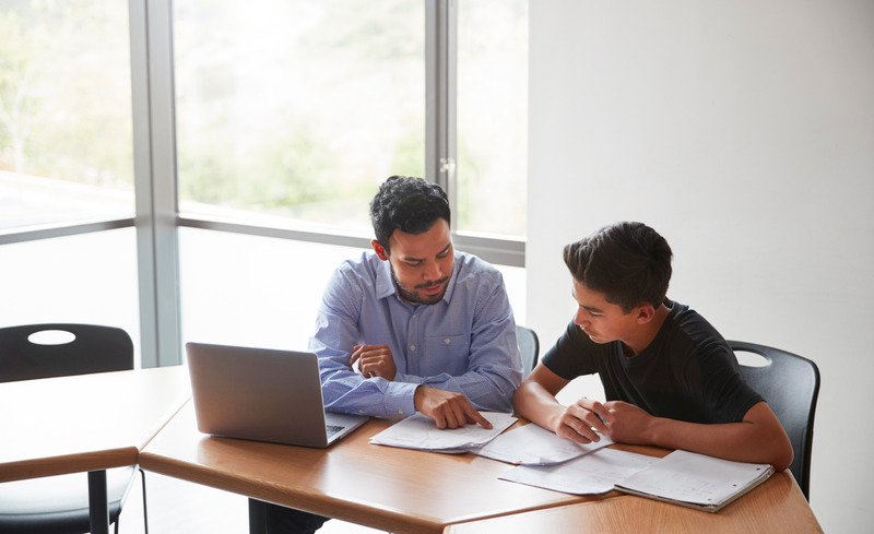 tutor with laptop working with student